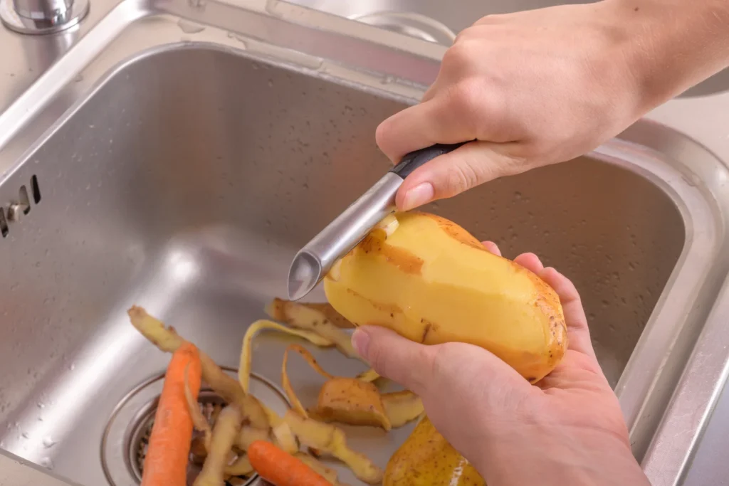 Peeling Potatoes into a kitchen sink garbage disposal