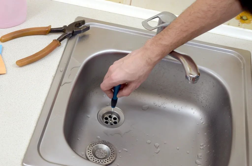 Plumber removing the cover on a clogged drain